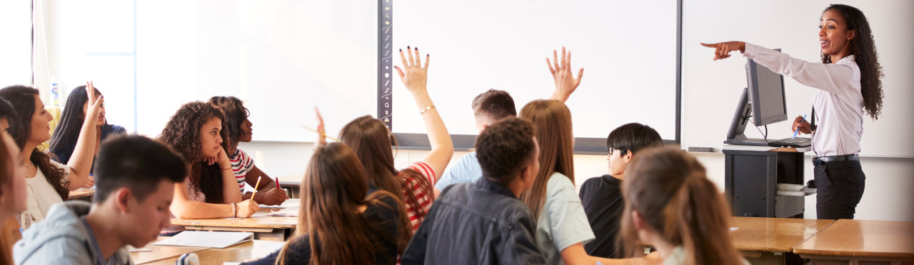 Une enseignante se tient devant sa classe dans une école secondaire