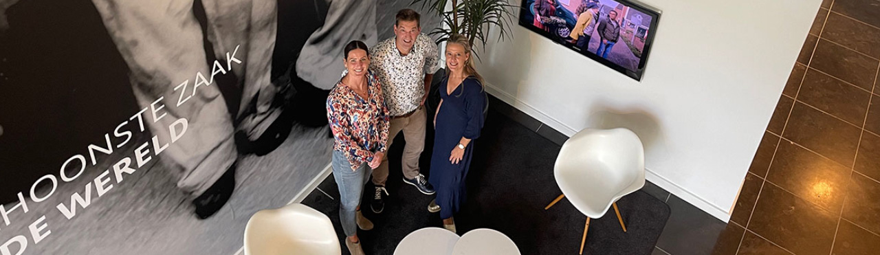 Trois collaborateurs de Toekomst Schoonmaakbedrijven posent en regardent vers le haut.